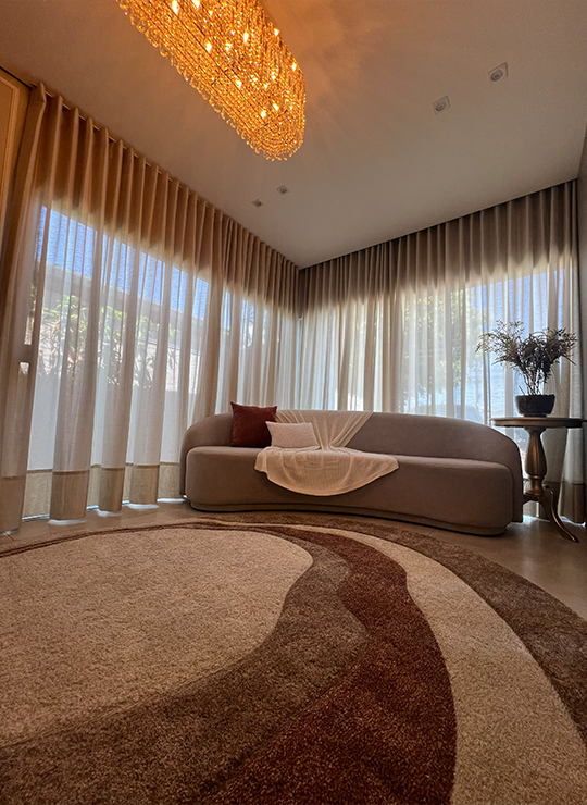 Lounge da sala da noiva com sofá curvo, cortinas em linho e lustre de cristal